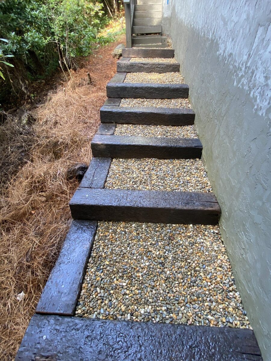 Railroad-tie steps with pea-gravel treads built along a home's foundation